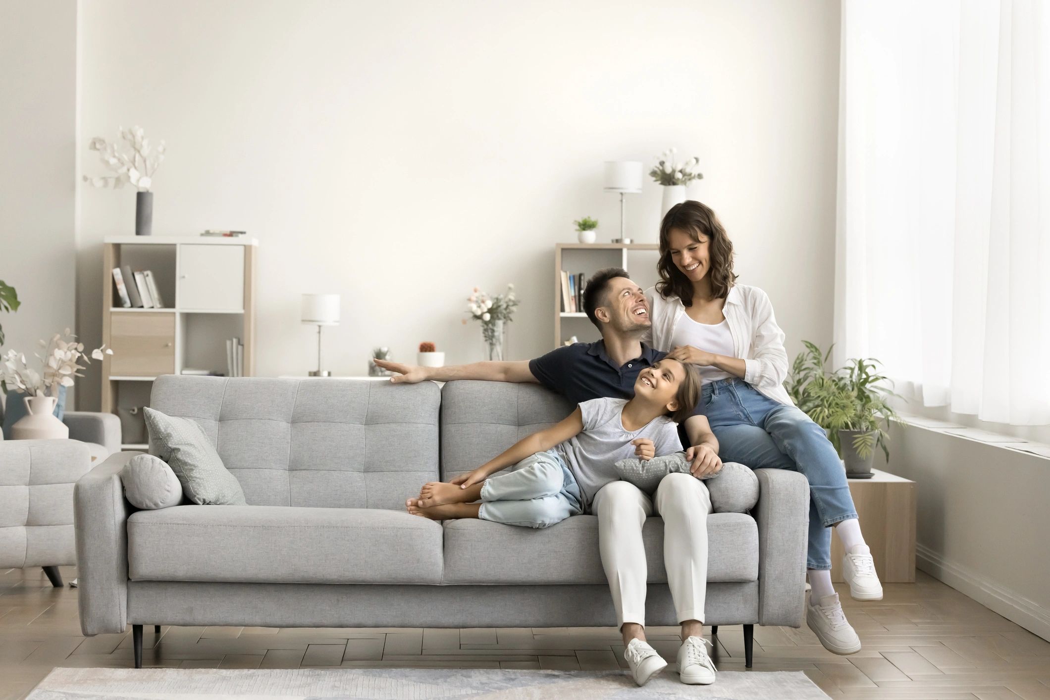 Parents and child relaxing together on a sofa in a cozy home